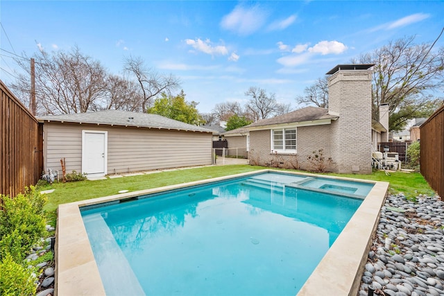 view of swimming pool featuring a fenced backyard, a pool with connected hot tub, an outdoor structure, and a yard