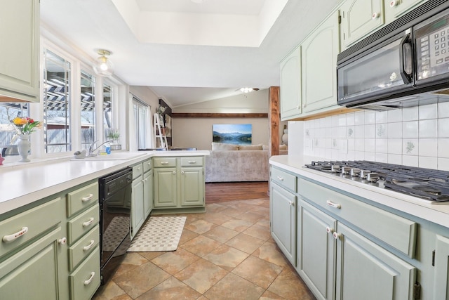 kitchen featuring tasteful backsplash, green cabinetry, light countertops, black appliances, and a sink