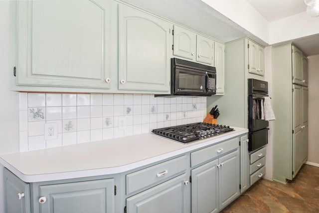 kitchen with a warming drawer, black appliances, gray cabinetry, light countertops, and decorative backsplash