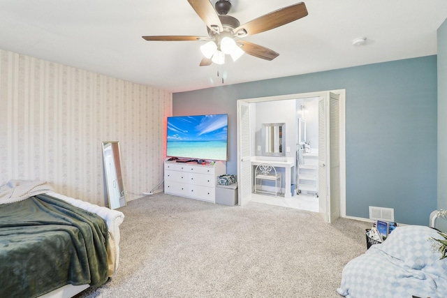 carpeted bedroom with wallpapered walls, baseboards, visible vents, and ceiling fan