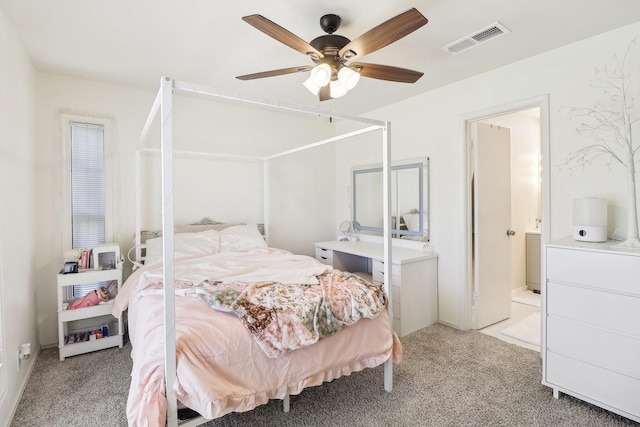 bedroom with a ceiling fan, visible vents, ensuite bathroom, and light carpet