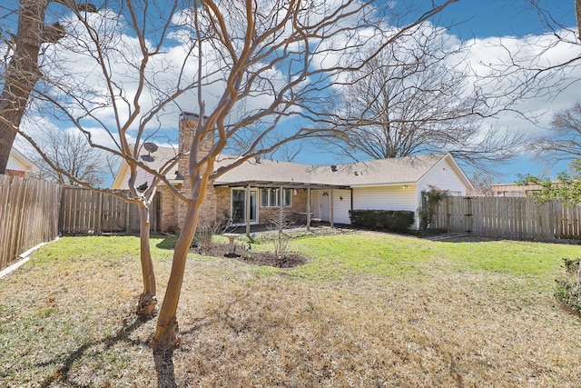 back of property with a yard and a fenced backyard