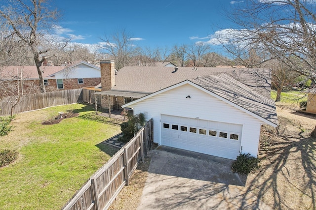 exterior space with a front yard, fence, roof with shingles, a chimney, and a garage