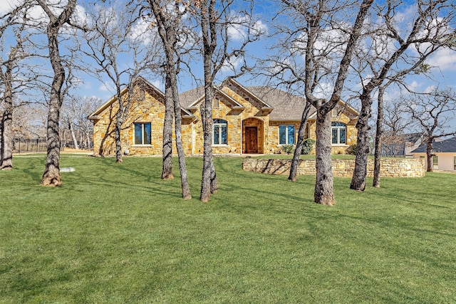 view of front of house with a front yard and stone siding