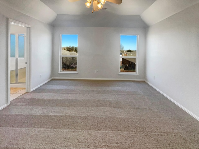 carpeted empty room with baseboards, ceiling fan, and vaulted ceiling