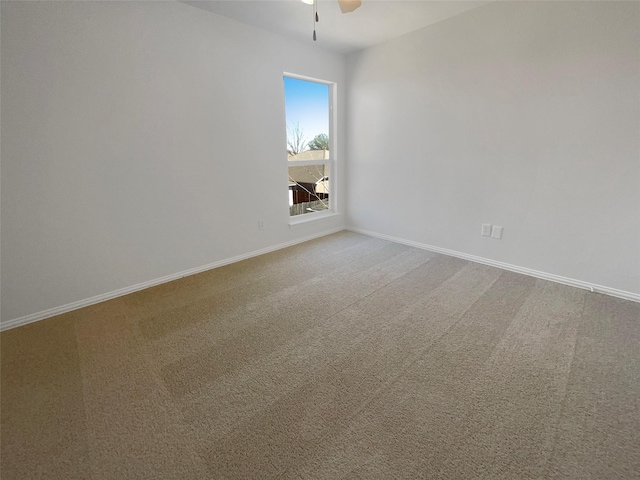 unfurnished room featuring carpet flooring, a ceiling fan, and baseboards