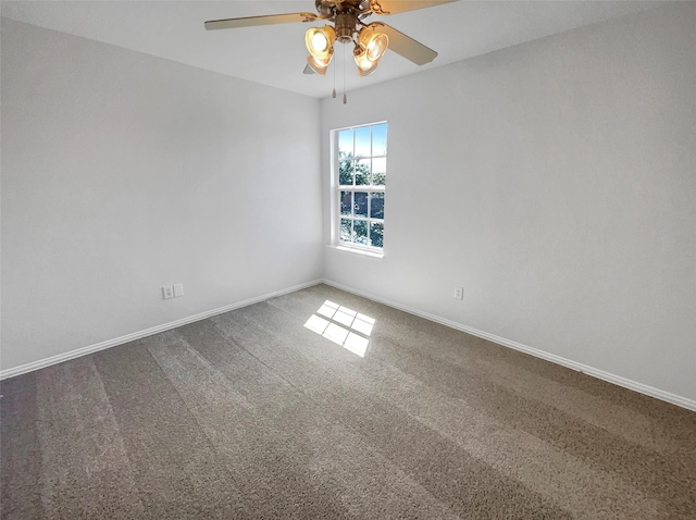 carpeted empty room featuring a ceiling fan and baseboards