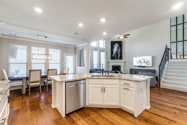 kitchen with visible vents, a sink, stainless steel dishwasher, open floor plan, and a fireplace