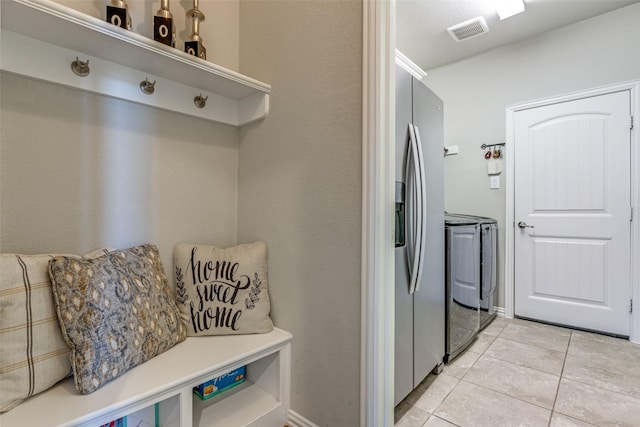 mudroom with light tile patterned floors, separate washer and dryer, and visible vents