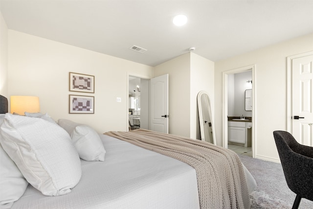 bedroom with carpet, baseboards, visible vents, a sink, and connected bathroom