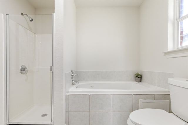 full bathroom featuring a stall shower, toilet, and a garden tub