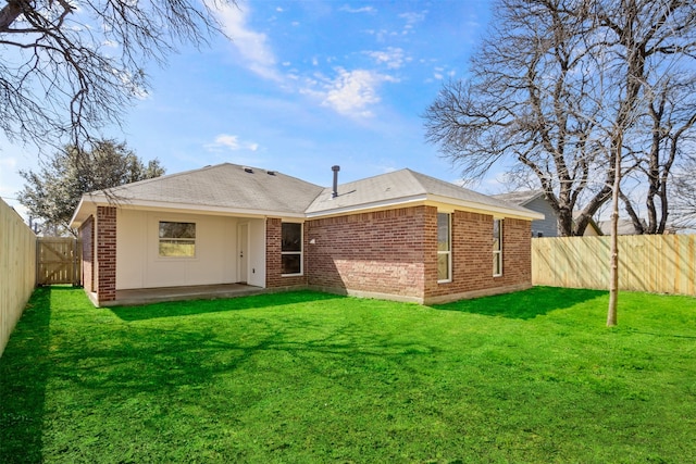 rear view of house featuring brick siding, a lawn, a patio, and a fenced backyard