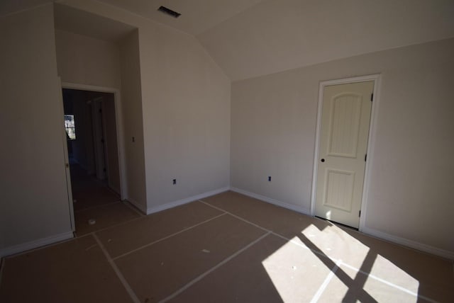 empty room featuring visible vents, baseboards, and vaulted ceiling