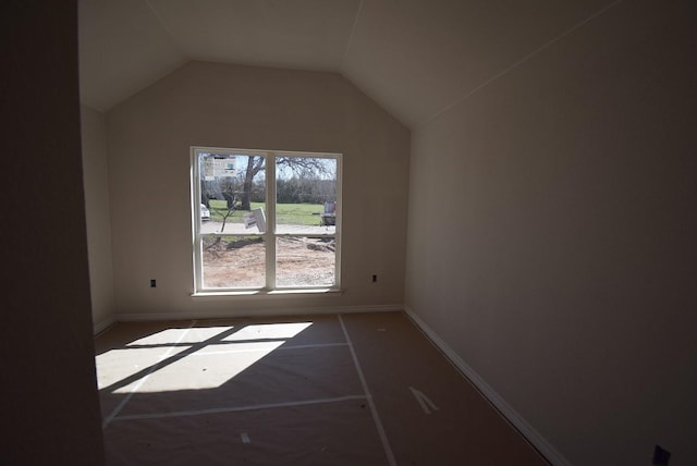 additional living space with baseboards and lofted ceiling