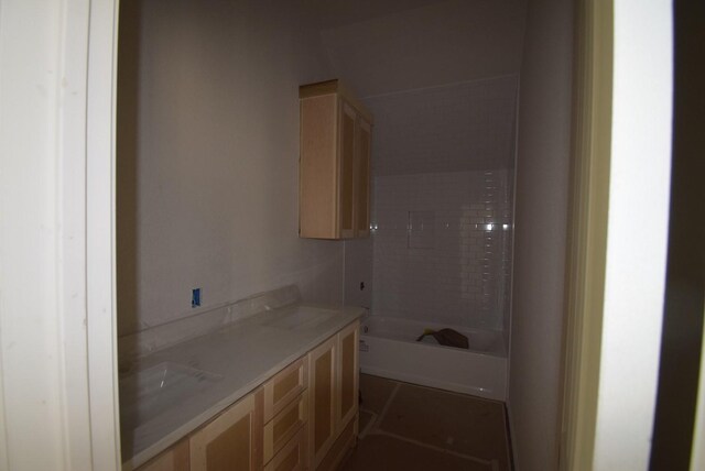 full bathroom with double vanity and washtub / shower combination