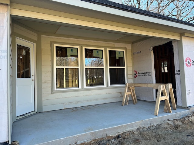 doorway to property with roof with shingles