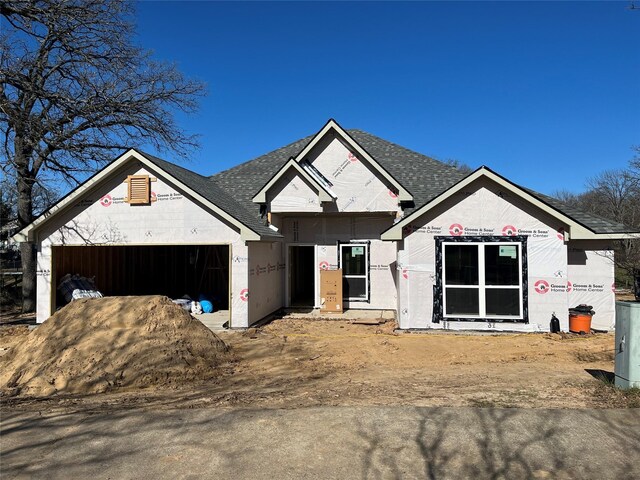 property under construction with roof with shingles and an attached garage