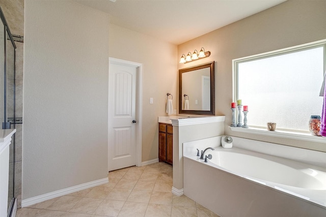 full bath with a shower stall, tile patterned floors, baseboards, a bath, and vanity