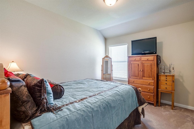 bedroom with light colored carpet, baseboards, and vaulted ceiling