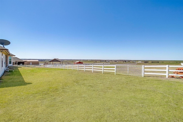 view of yard featuring a rural view, an enclosed area, and fence