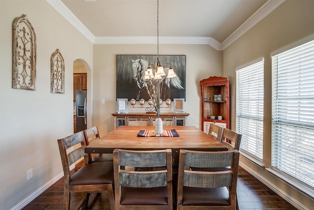 dining room featuring dark wood-type flooring, crown molding, arched walkways, and baseboards