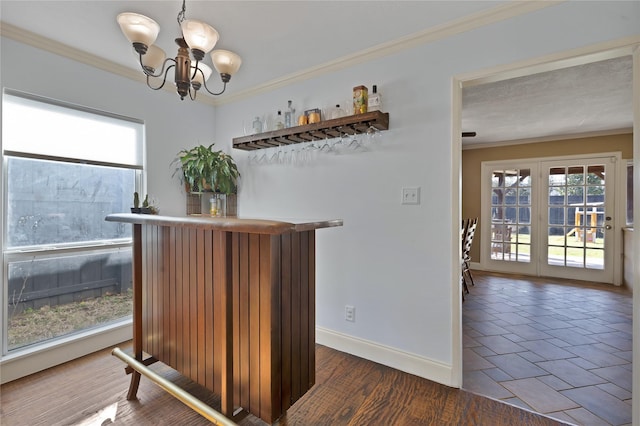 bar featuring crown molding, a dry bar, and a healthy amount of sunlight