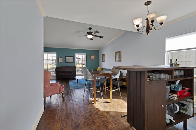 dining area featuring lofted ceiling, ceiling fan with notable chandelier, wood finished floors, crown molding, and baseboards