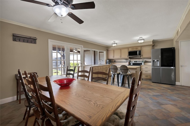 dining area with stone finish flooring, ceiling fan, crown molding, baseboards, and french doors