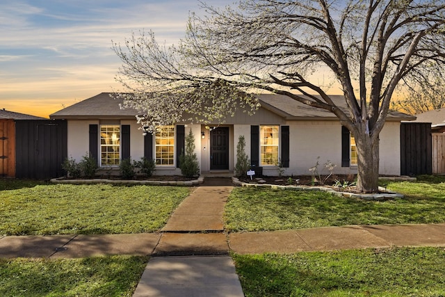 view of front of property featuring a lawn and fence