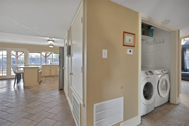 washroom with visible vents, laundry area, a sink, stone finish floor, and independent washer and dryer