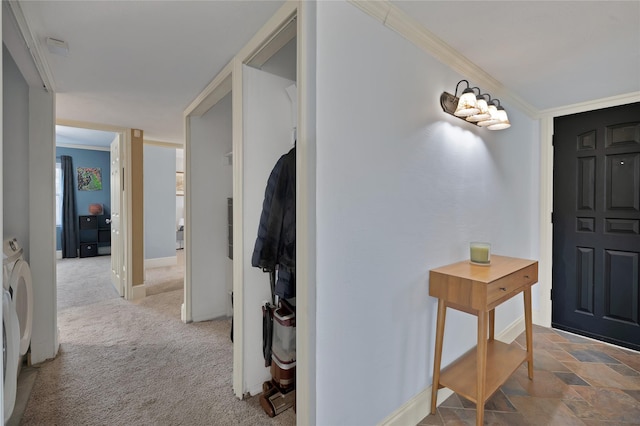 foyer entrance featuring baseboards, carpet, washing machine and dryer, and crown molding