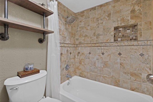 bathroom with a textured wall, toilet, and shower / bath combination with curtain