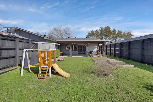 back of property featuring a patio area, a playground, a yard, and fence