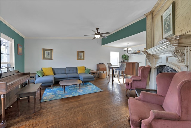 living area with ceiling fan with notable chandelier, a fireplace, wood finished floors, and ornamental molding