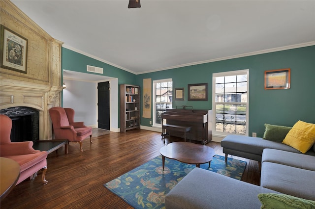 living room with visible vents, wood finished floors, crown molding, a premium fireplace, and baseboards