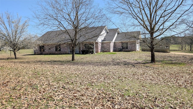 view of side of property featuring a yard and brick siding