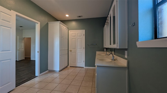 bathroom featuring a sink, visible vents, baseboards, and tile patterned flooring