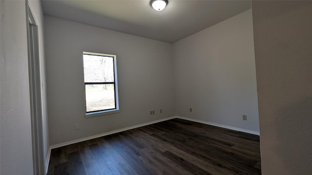 empty room featuring baseboards and dark wood-style flooring