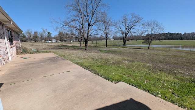 view of yard featuring a patio and a water view