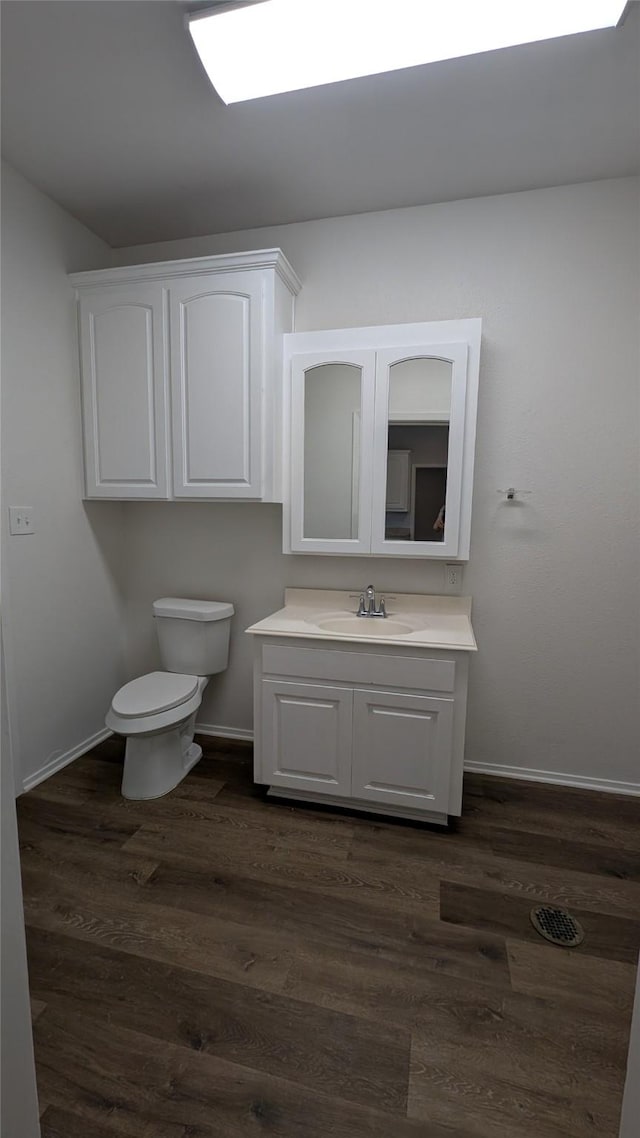 bathroom with vanity, baseboards, and wood finished floors