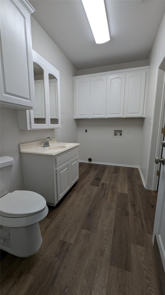 interior space featuring toilet, vanity, baseboards, and wood finished floors