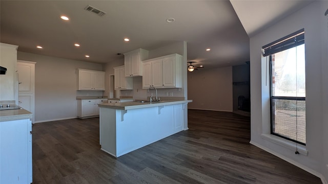 kitchen with a sink, visible vents, white cabinets, and recessed lighting