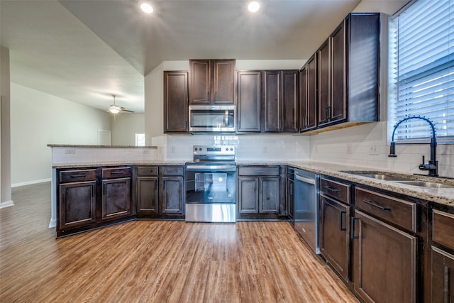 900 Juneberry Dr, Denton, TX 76207 - kitchen with backsplash, light wood-style floors, appliances with stainless steel finishes, and a sink
