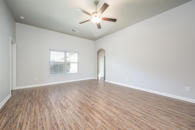 900 Juneberry Dr, Denton, TX 76207 - unfurnished room with arched walkways, baseboards, a ceiling fan, and wood finished floors