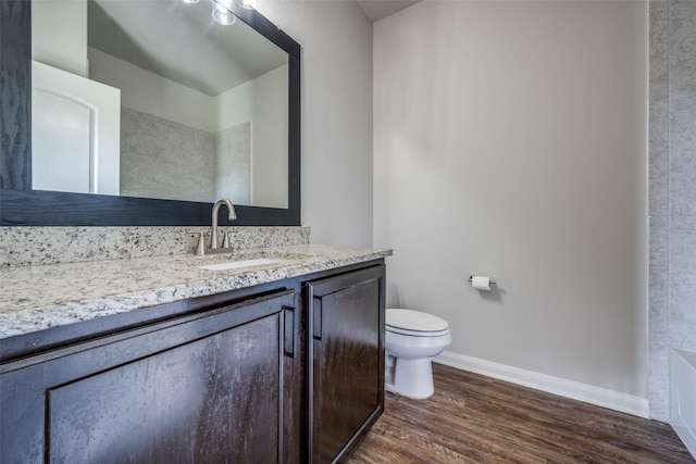 900 Juneberry Dr, Denton, TX 76207 - bathroom featuring vanity, toilet, wood finished floors, and baseboards