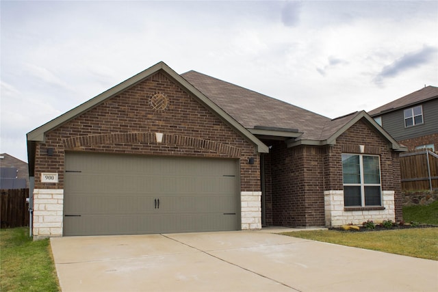 view of front of house with stone siding, roof with shingles, concrete driveway, an attached garage, and brick siding