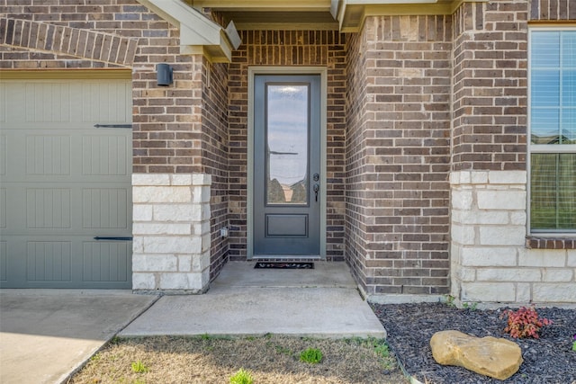 900 Juneberry Dr, Denton, TX 76207 - doorway to property featuring an attached garage, brick siding, and stone siding