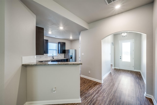 900 Juneberry Dr, Denton, TX 76207 - kitchen with baseboards, arched walkways, dark wood-style flooring, and stainless steel refrigerator with ice dispenser