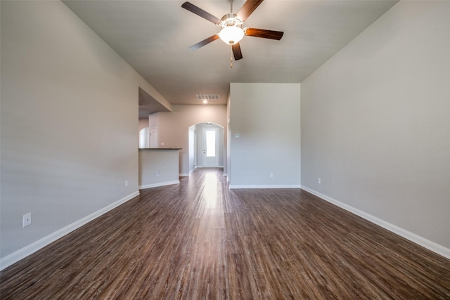 900 Juneberry Dr, Denton, TX 76207 - unfurnished living room with visible vents, baseboards, dark wood-style floors, arched walkways, and a ceiling fan