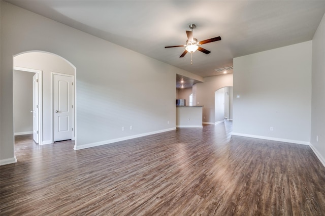 900 Juneberry Dr, Denton, TX 76207 - unfurnished living room with visible vents, baseboards, ceiling fan, dark wood finished floors, and arched walkways